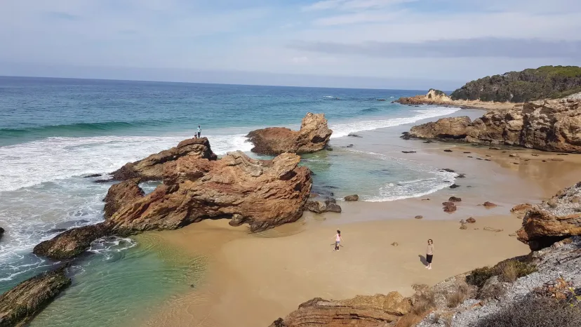 Turquoise water and sculpted rocks on a sandy cove near Mallacoota.